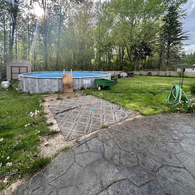 view of yard with a storage shed, an outdoor pool, an outdoor structure, and a patio