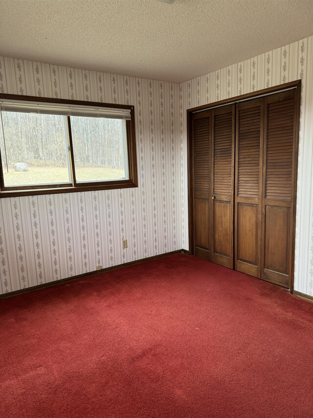 3135 Montgomery Rd, Bellaire, MI 49615 - unfurnished bedroom featuring carpet flooring, a textured ceiling, and a closet