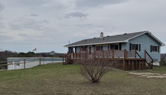 3135 Montgomery Rd, Bellaire, MI 49615 - back of property with a lawn, a deck, and a chimney
