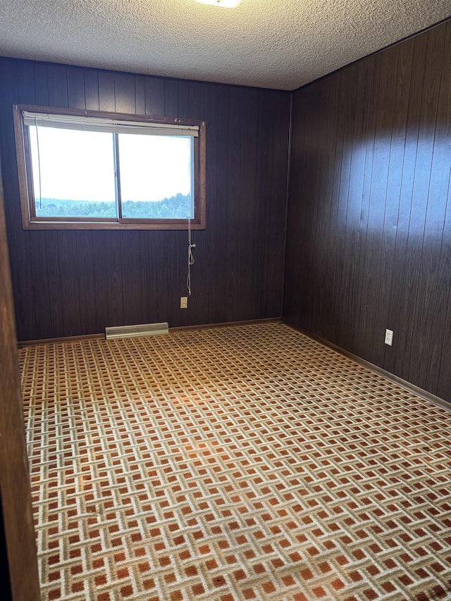 3135 Montgomery Rd, Bellaire, MI 49615 - empty room featuring wooden walls and a textured ceiling