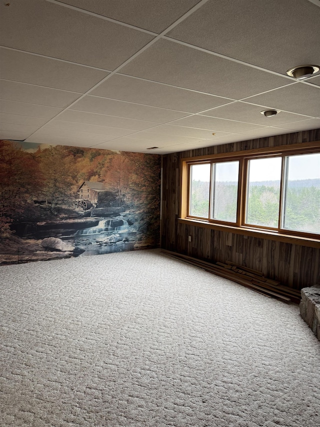 3135 Montgomery Rd, Bellaire, MI 49615 - empty room with wooden walls, carpet, and a drop ceiling