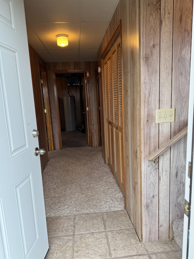 3135 Montgomery Rd, Bellaire, MI 49615 - hall with gas water heater, light colored carpet, wooden walls, and light tile patterned floors
