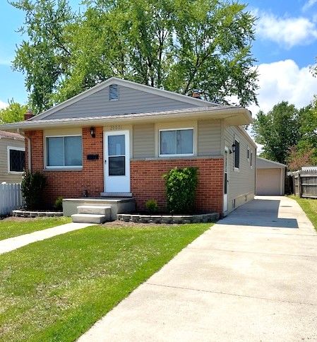 bungalow-style house featuring brick siding and a detached garage