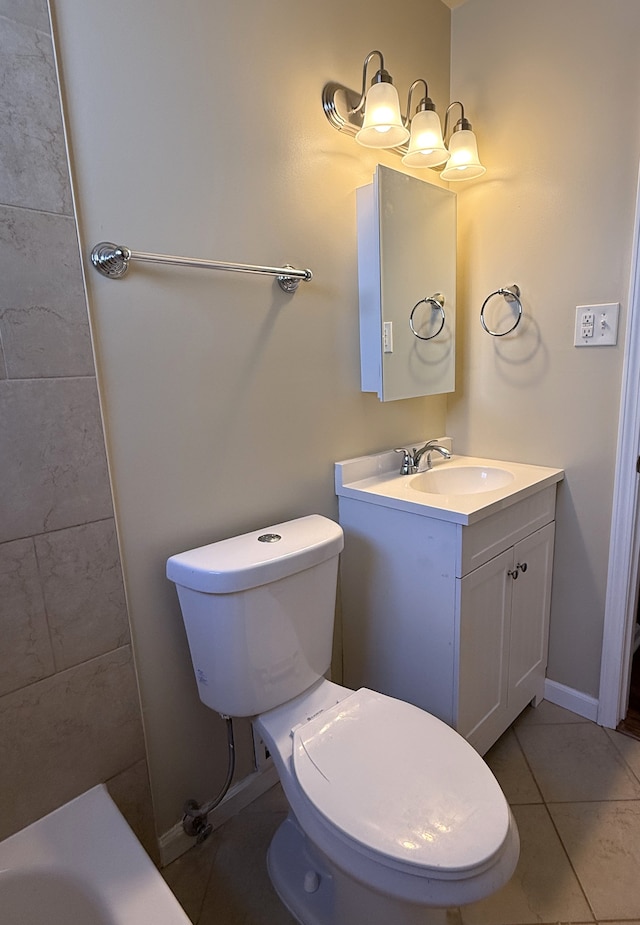 bathroom featuring toilet, baseboards, and vanity