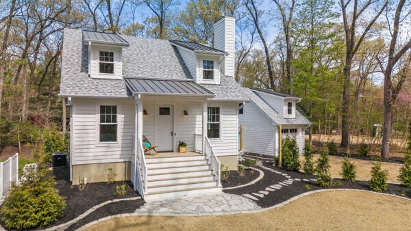 4108 Chippewa Trl, New Buffalo, MI 49117 - view of front of property with a standing seam roof, a chimney, covered porch, metal roof, and a shingled roof