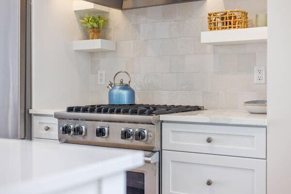 4108 Chippewa Trl, New Buffalo, MI 49117 - kitchen featuring open shelves, high end stove, tasteful backsplash, and white cabinetry