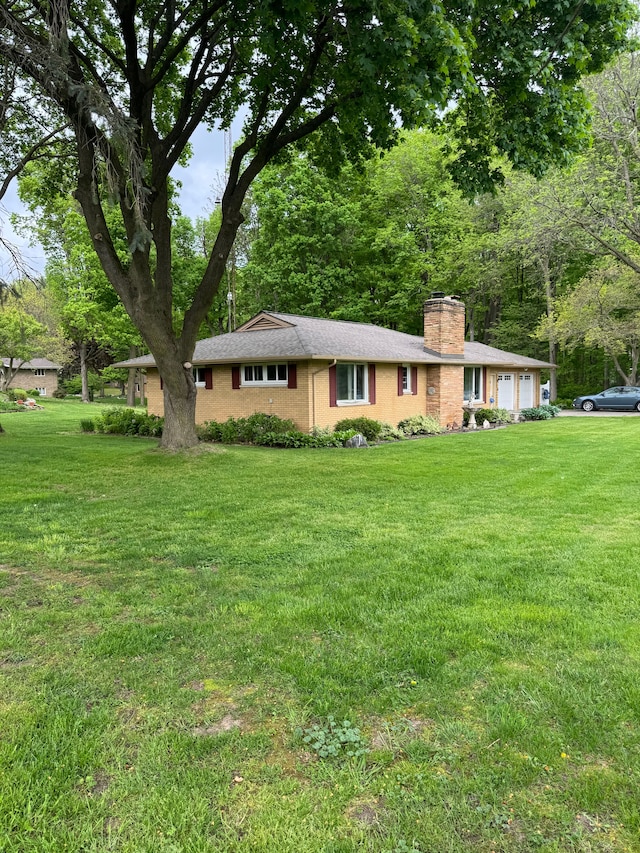 2071 N Belsay Rd, Burton, MI 48509 - ranch-style home featuring a front lawn, a chimney, brick siding, and an attached garage