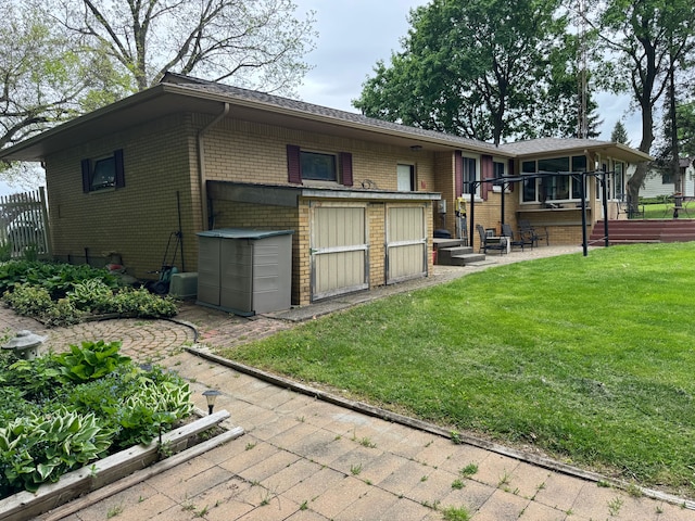 2071 N Belsay Rd, Burton, MI 48509 - rear view of property with a yard, brick siding, an outbuilding, and a storage shed