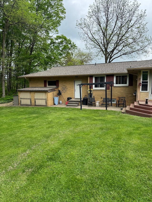 2071 N Belsay Rd, Burton, MI 48509 - back of property with brick siding, a lawn, and a patio