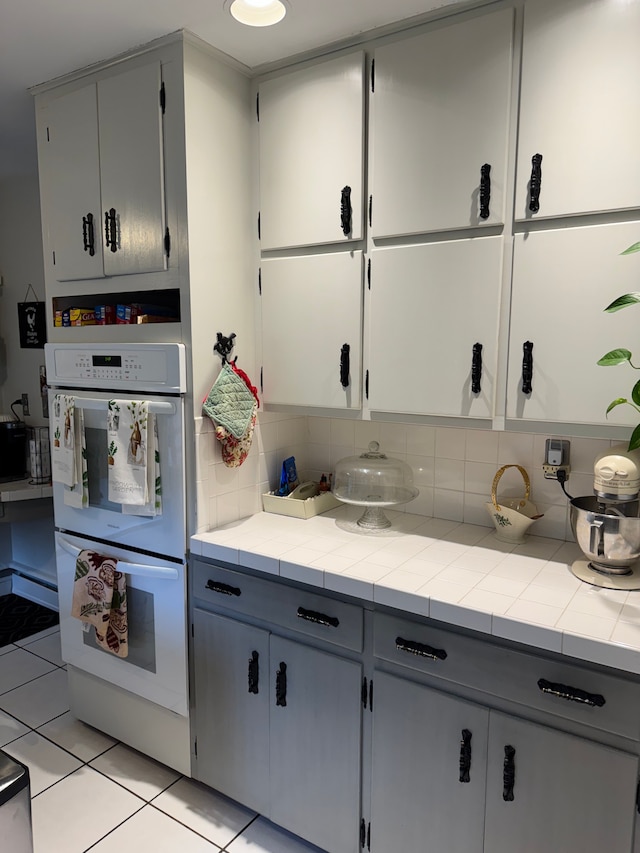 2071 N Belsay Rd, Burton, MI 48509 - kitchen with double oven, tasteful backsplash, light tile patterned floors, and tile countertops