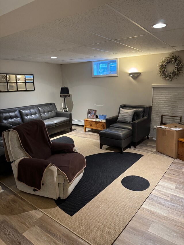 2071 N Belsay Rd, Burton, MI 48509 - living area featuring wood finished floors, a baseboard heating unit, a paneled ceiling, and recessed lighting