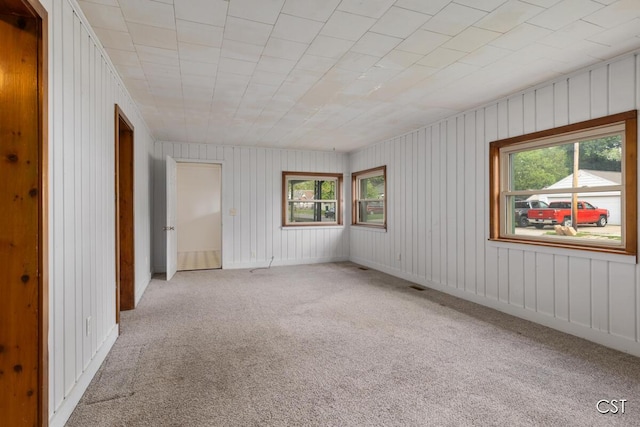 1001 Kelsey Ave, Lansing, MI 48910 - empty room with healthy amount of natural light and carpet flooring