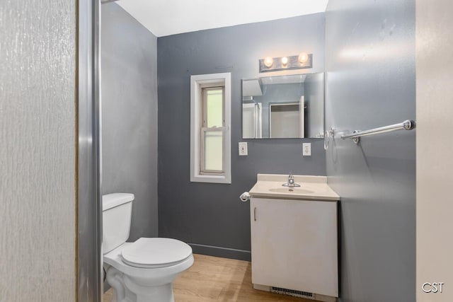 1001 Kelsey Ave, Lansing, MI 48910 - bathroom featuring toilet, wood finished floors, vanity, and baseboards
