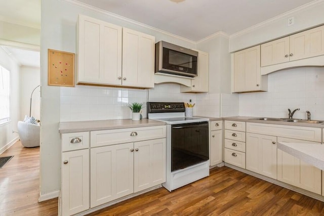 2520 S State St, Saint Joseph, MI 49085 - kitchen featuring range with electric cooktop, stainless steel microwave, a sink, ornamental molding, and light countertops