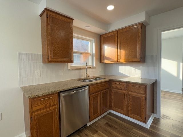 kitchen with dishwasher, a sink, dark wood finished floors, brown cabinetry, and recessed lighting
