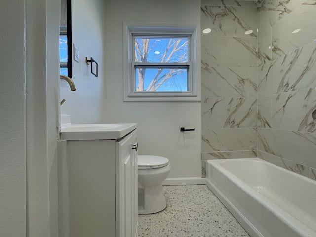 bathroom with baseboards, toilet, vanity, shower / bathtub combination, and speckle patterned floor