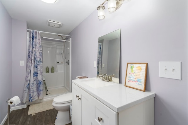 full bathroom with wood finished floors, a stall shower, toilet, vanity, and baseboards
