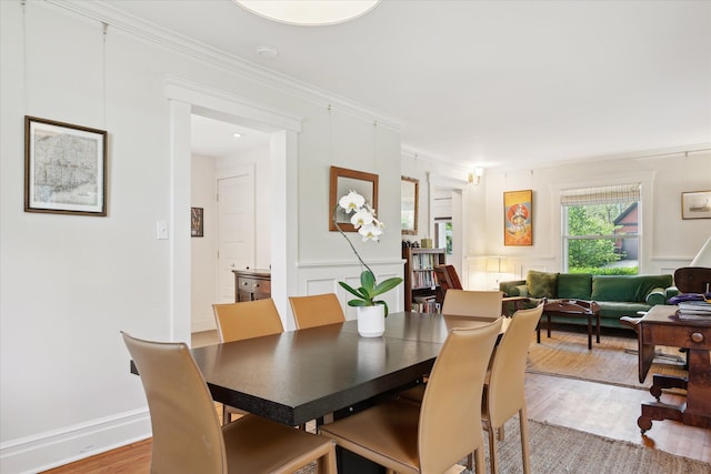 314 W Madison St, Ann Arbor, MI 48103 - dining space with light wood finished floors, a decorative wall, and ornamental molding