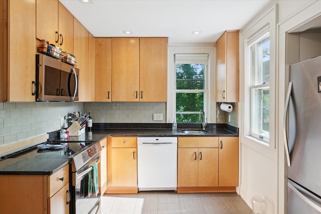 314 W Madison St, Ann Arbor, MI 48103 - kitchen with appliances with stainless steel finishes, a sink, backsplash, dark stone counters, and recessed lighting