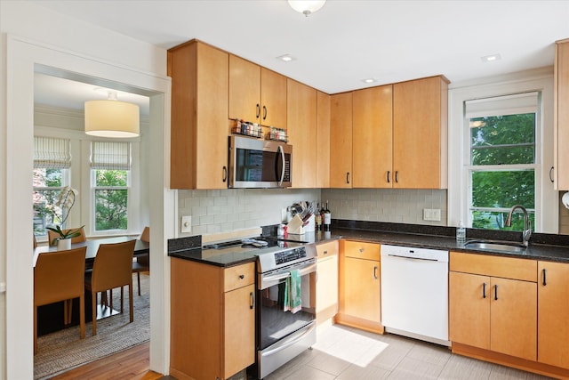 314 W Madison St, Ann Arbor, MI 48103 - kitchen featuring appliances with stainless steel finishes, a sink, tasteful backsplash, and dark stone countertops