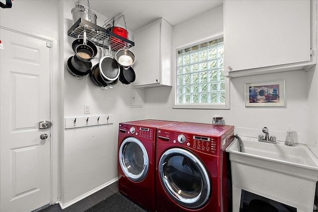 laundry room with cabinet space, washer and clothes dryer, dark tile patterned floors, and baseboards