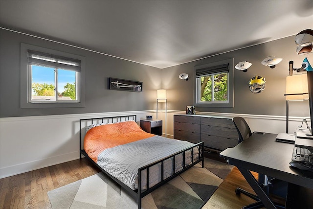 bedroom featuring wood finished floors, a desk, and baseboards