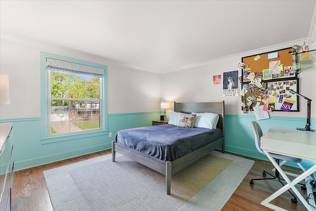 bedroom with ornamental molding, wood finished floors, and an office area