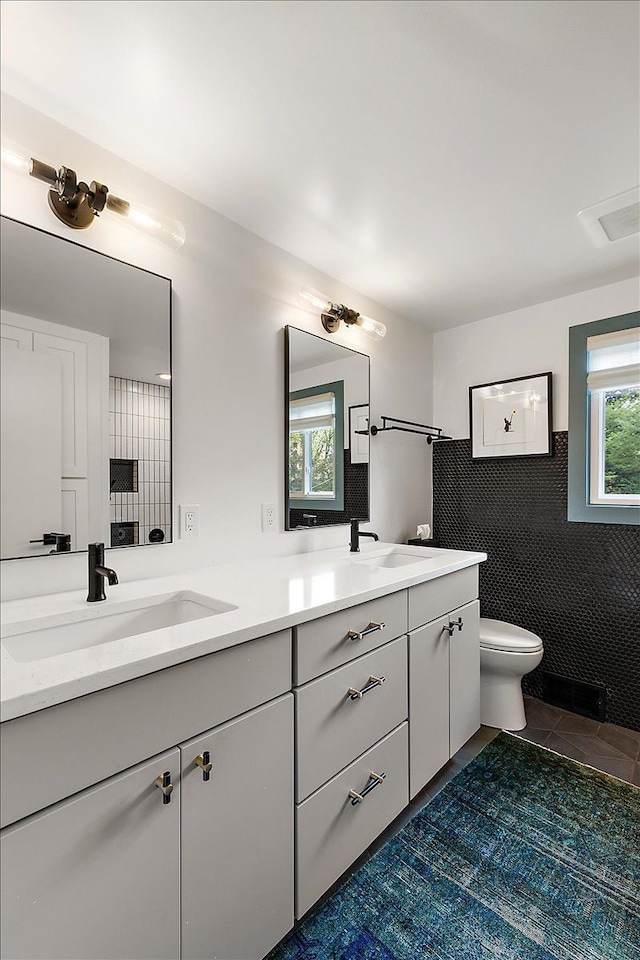 full bath featuring double vanity, toilet, and tile patterned floors