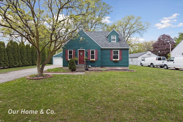 700 Scheurmann St, Essexville, MI 48732 - cape cod home with a front yard, a detached garage, and a shingled roof