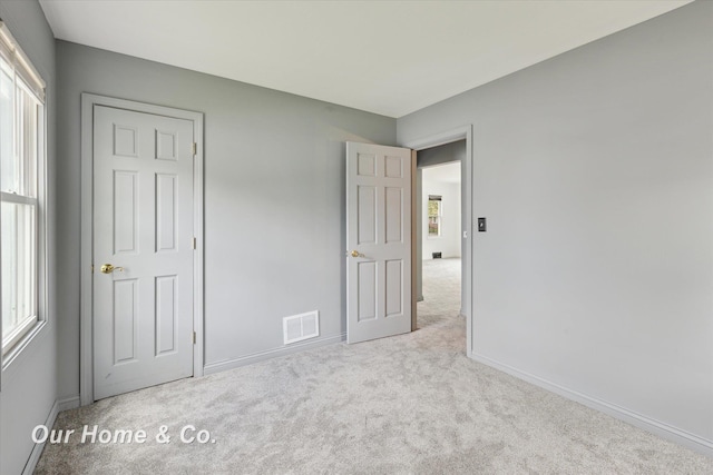700 Scheurmann St, Essexville, MI 48732 - unfurnished bedroom featuring carpet floors, multiple windows, and baseboards