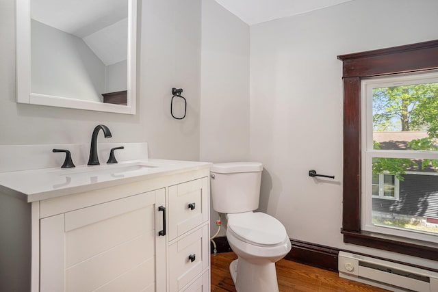 24 W Bernard St, Hartford, MI 49057 - half bath featuring baseboard heating, wood finished floors, toilet, vanity, and vaulted ceiling