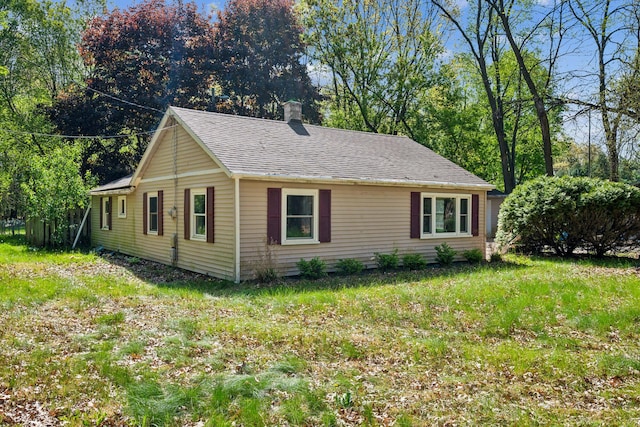 view of front of home with a chimney and a shingled roof