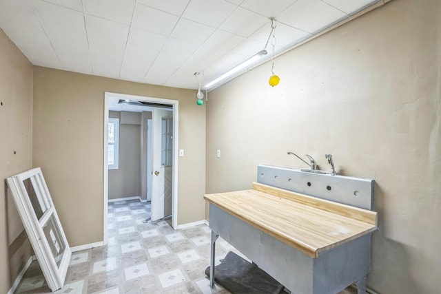 hallway featuring light flooring and baseboards