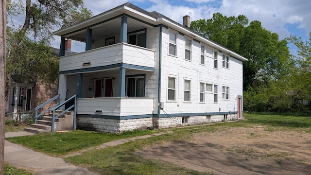 39 Iona Ave, Muskegon, MI 49442 - view of front of property with a balcony, a chimney, and a front lawn