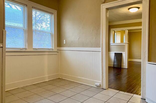 39 Iona Ave, Muskegon, MI 49442 - spare room with a wainscoted wall, light tile patterned floors, and baseboards