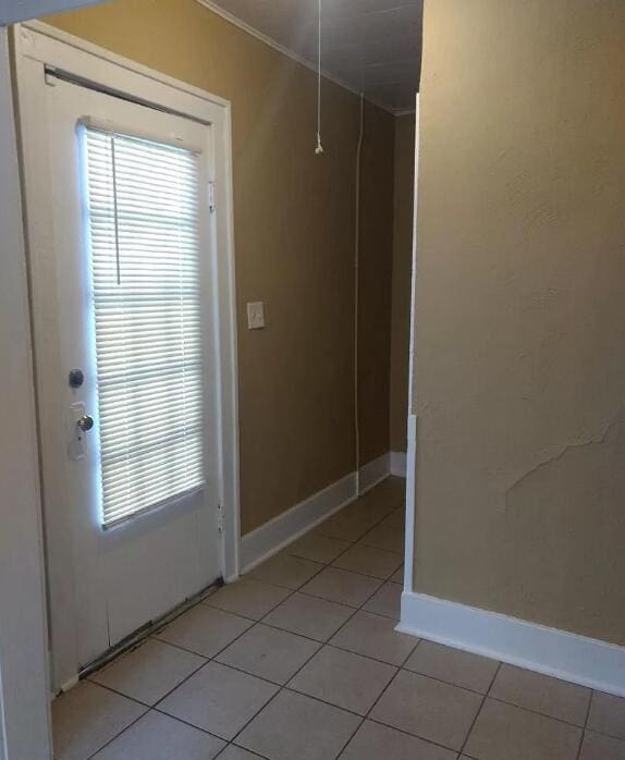 39 Iona Ave, Muskegon, MI 49442 - doorway to outside featuring light tile patterned flooring, baseboards, and crown molding