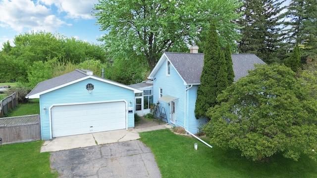 view of front of house featuring a garage, asphalt driveway, a shingled roof, a chimney, and view of scattered trees