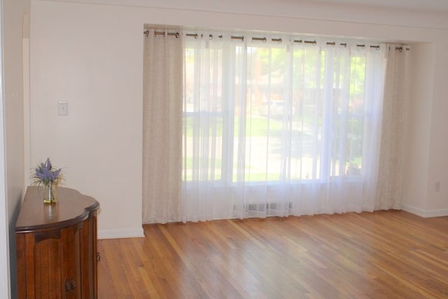 empty room featuring light wood finished floors and baseboards