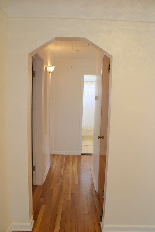 corridor featuring wood finished floors and baseboards