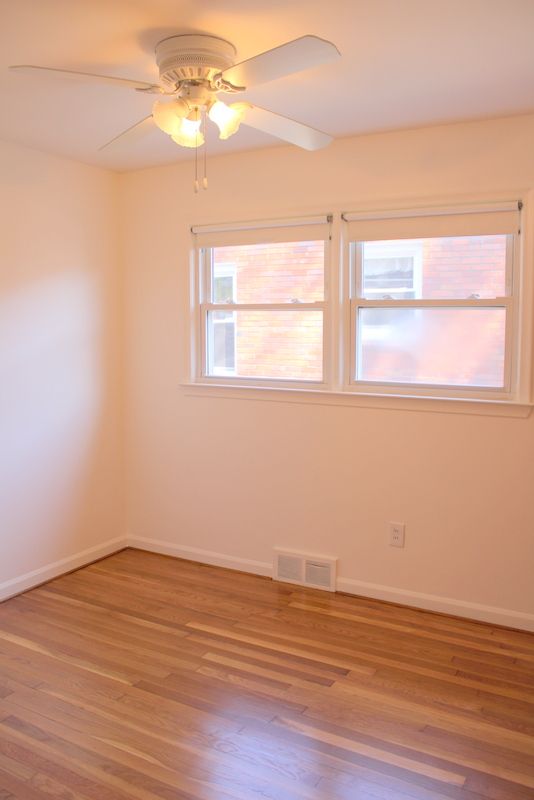 unfurnished room with light wood finished floors, a ceiling fan, and baseboards