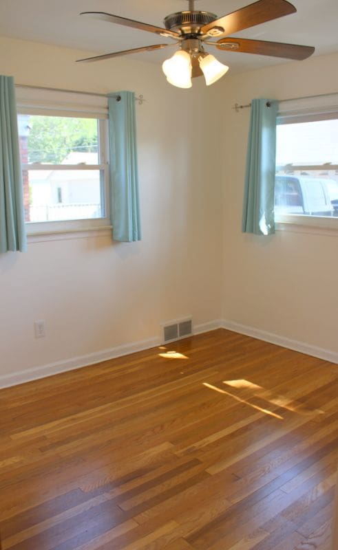 spare room featuring a ceiling fan, wood finished floors, and baseboards