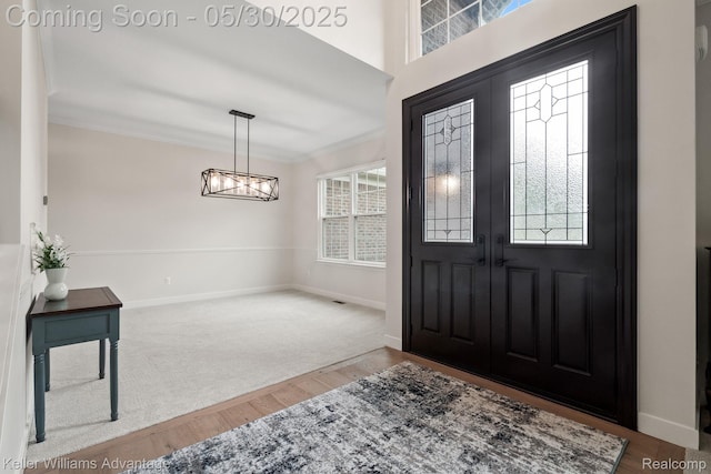 41740 Steinbeck Gln, Novi, MI 48377 - foyer entrance with wood finished floors, a chandelier, baseboards, and crown molding
