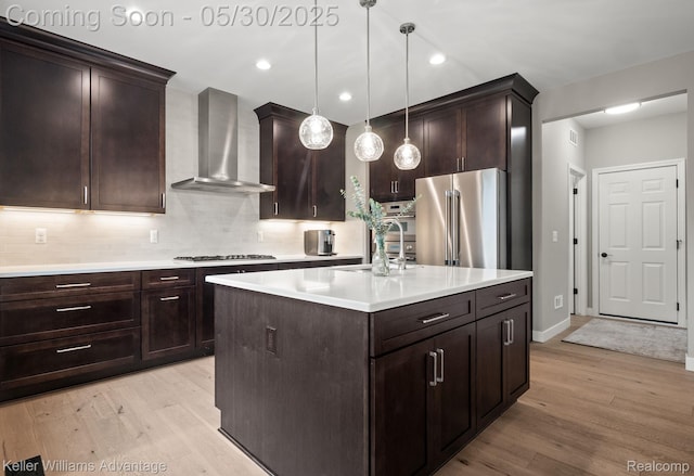 41740 Steinbeck Gln, Novi, MI 48377 - kitchen featuring appliances with stainless steel finishes, wall chimney range hood, a sink, light wood-type flooring, and recessed lighting