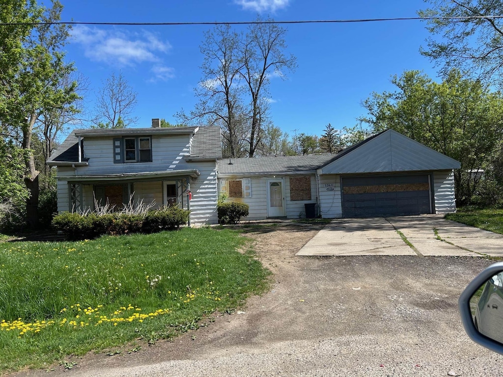 view of front of house featuring driveway, a front yard, a garage, and a chimney