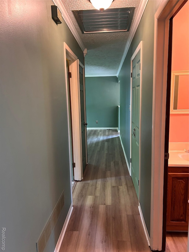 809 Isbell St, Howell, MI 48843 - hall with ornamental molding, a textured ceiling, wood finished floors, and a sink