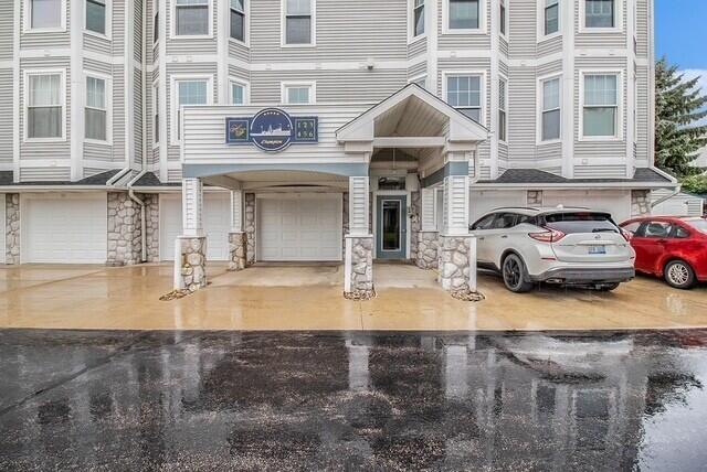 300 S Rath Ave Unit 1, Ludington, MI 49431 - view of front of property featuring stone siding and an attached garage