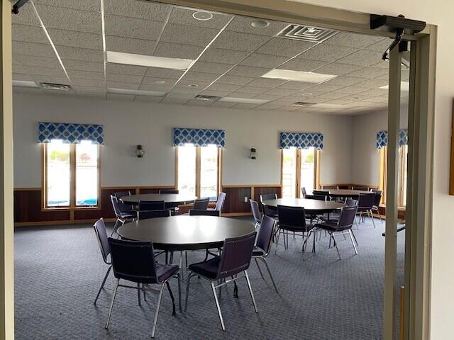 300 S Rath Ave Unit 1, Ludington, MI 49431 - carpeted dining space with a drop ceiling, wainscoting, and healthy amount of natural light