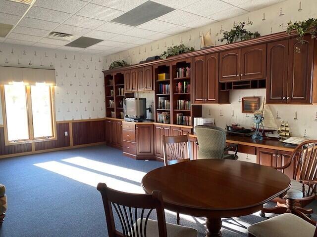 300 S Rath Ave Unit 1, Ludington, MI 49431 - kitchen featuring wainscoting, open shelves, and a drop ceiling