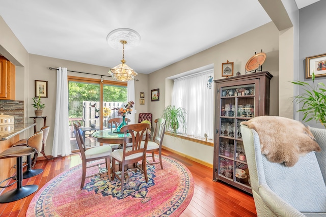 652 S Military St, Dearborn, MI 48124 - dining area with a chandelier, light wood-type flooring, baseboards, and arched walkways