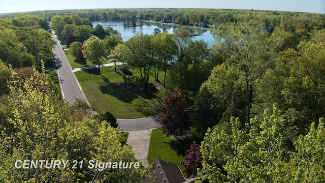 aerial view of property's location with a nearby body of water and a heavily wooded area